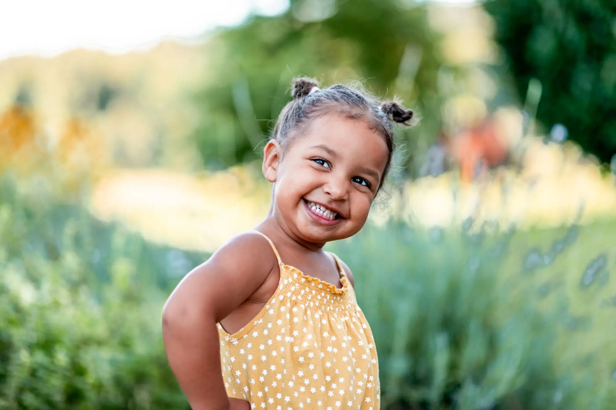 A smiling young child with star clothes, set against a light background, illustrates how early orthodontics can benefit your child's smile through interceptive treatment at Pediatric Dentistry and Orthodontics of Forsyth - Cumming in Cumming, GA.