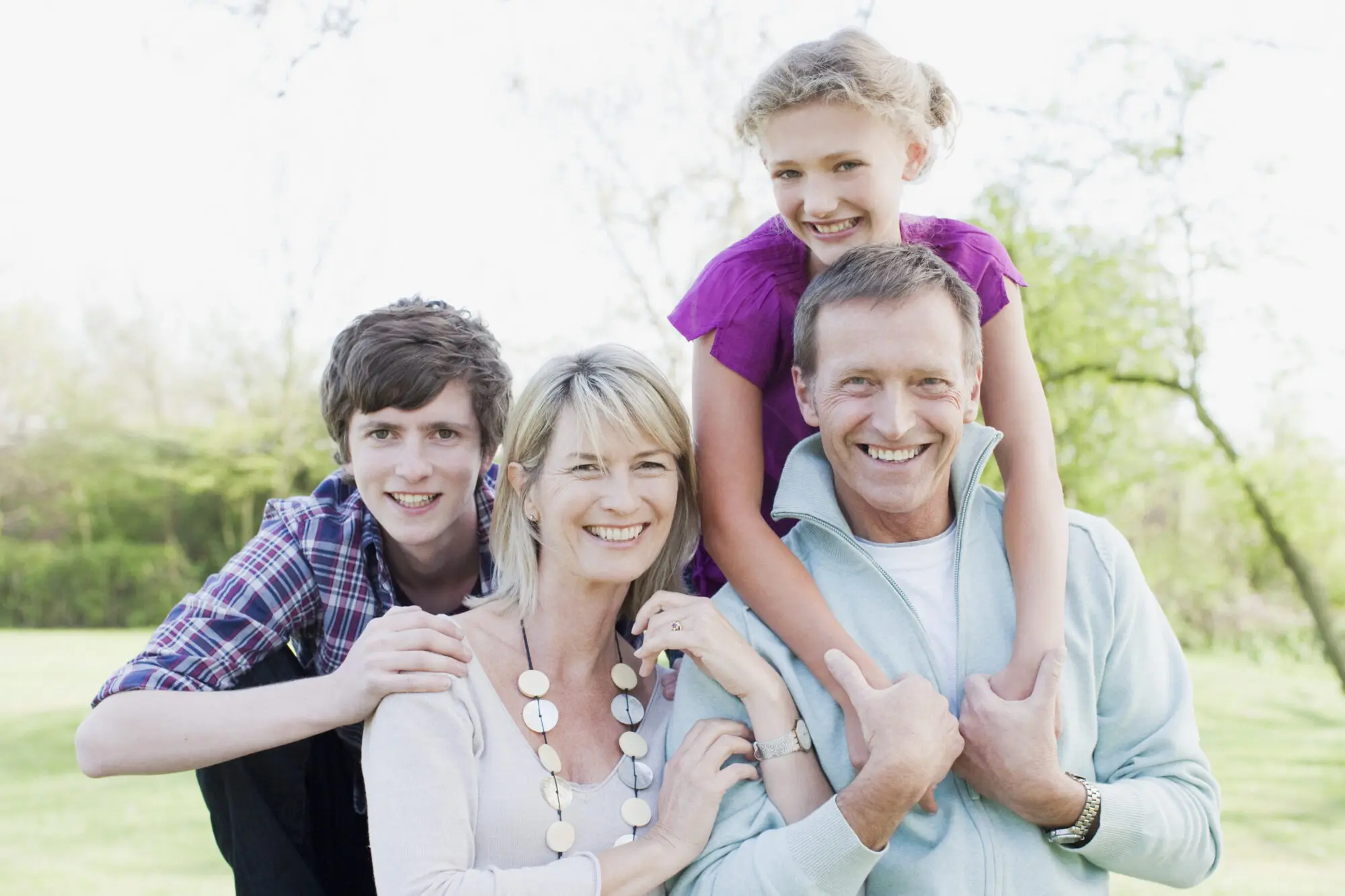 Smiling family hugging outdoors Clear Aligners