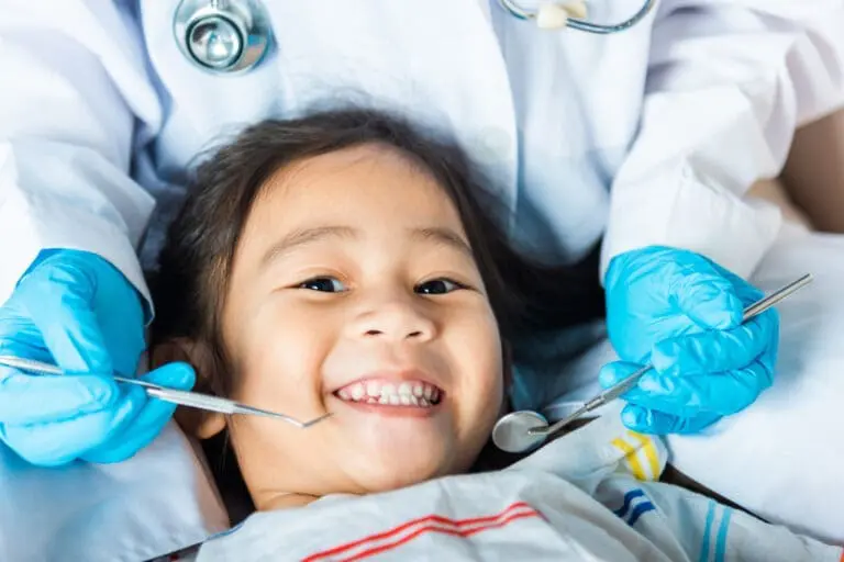 Young patient smiles at Pediatric Dentistry and Orthodontics of Forsyth - Cumming in Cumming, GA.