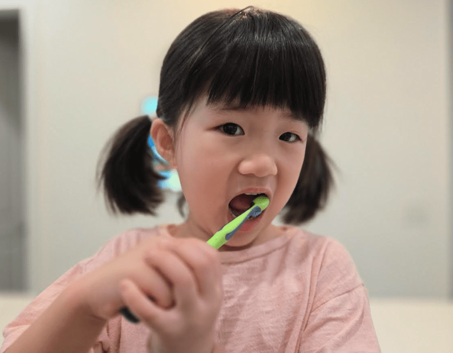 At Pediatric Dentistry and Orthodontics of Forsyth - Cumming in Cumming, GA. A young child practices preventive pediatric dental care by brushing their teeth and using mouthwash, learning about fluoride treatments and safety guidelines.