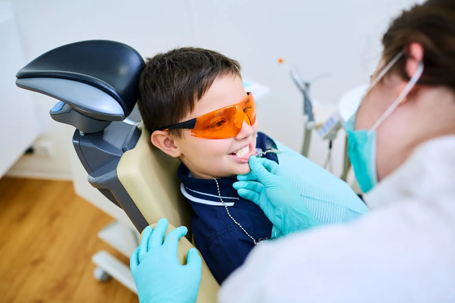 At Pediatric Dentistry and Orthodontics of Forsyth - Cumming in Cumming GA, a dentist provides safe and precise care Laser Dentistry for children from infants to teens, examining a young girl.