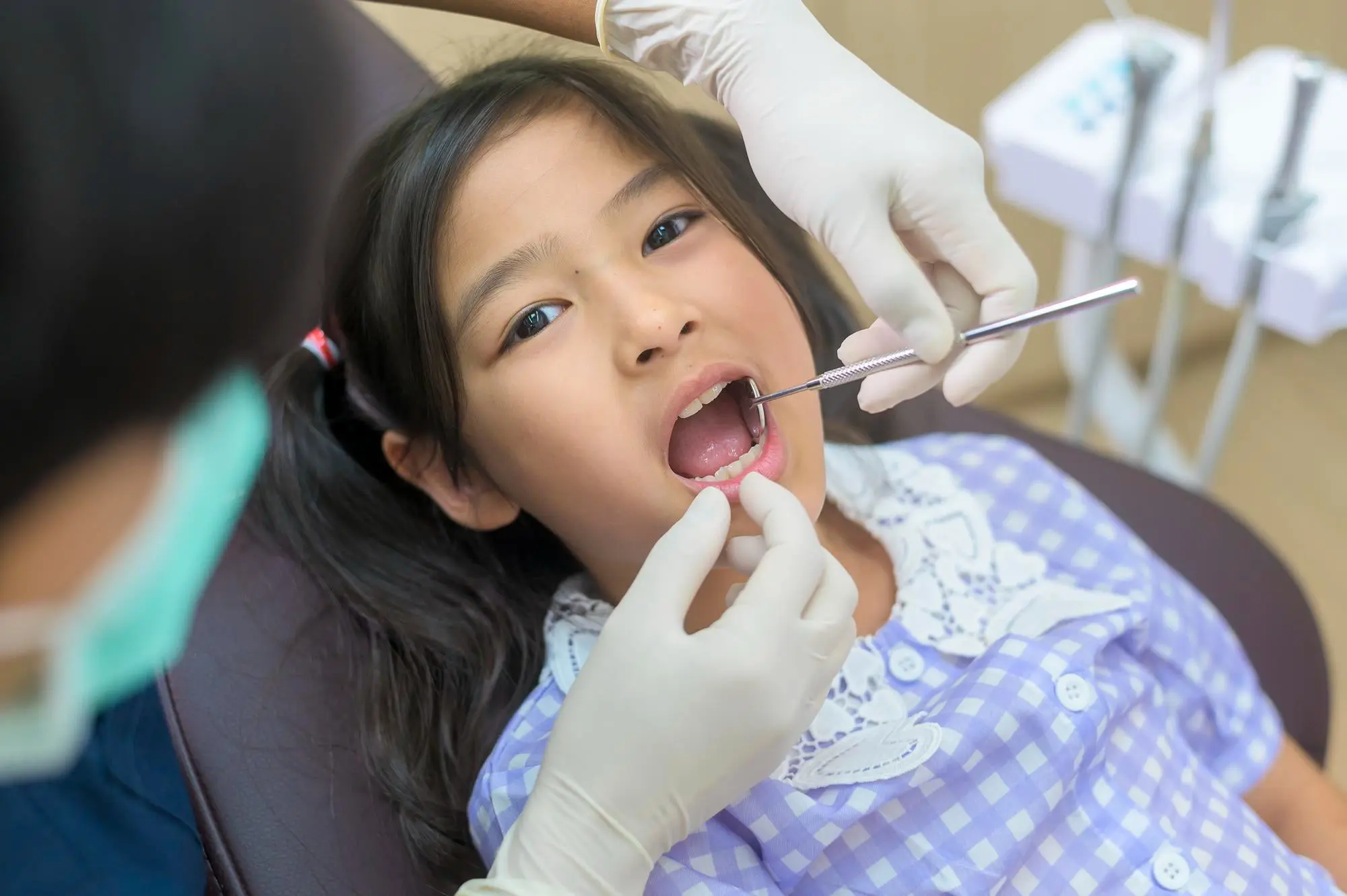A Friendly Dentist gently examines the teeth of a child with Autism Spectrum Disorder, offering specialized dental care at Pediatric Dentistry and Orthodontics of Forsyth - Cumming in Cumming, GA.