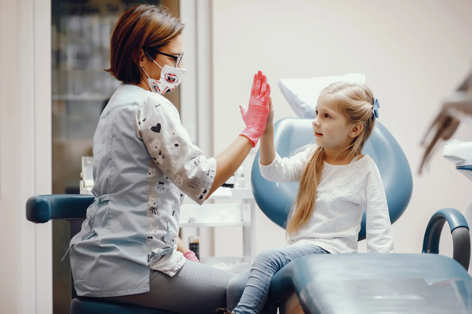 A Friendly Dentist skilled in behavioral management and communication techniques discuss about dental treatment with young girl in a brightly lit clinic in Cumming, GA.