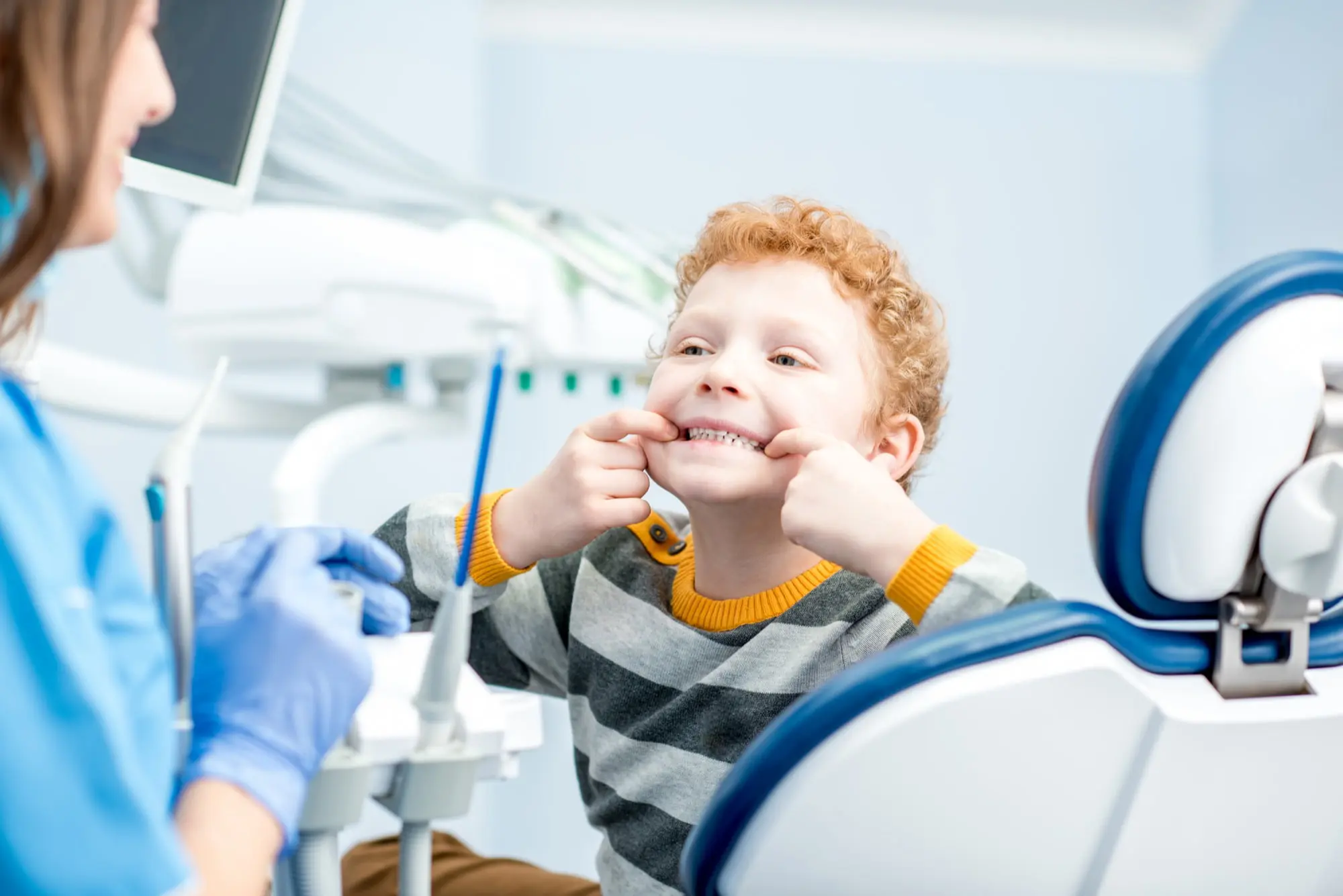 At Pediatric Dentistry and Orthodontics of Forsyth - Cumming in Cumming GA, a dentist examines a young boy teeth during restorative dental care—ensuring kids’ smiles stay healthy with services covered by Apple Health.