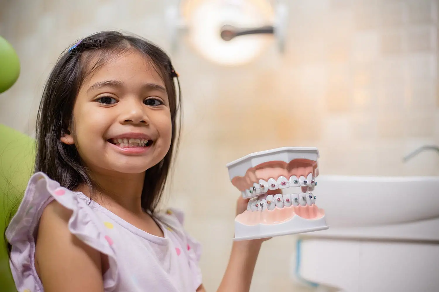 At Pediatric Dentistry and Orthodontics of Forsyth - Cumming in Cumming GA, a dentist uses specialized instruments to examine a child's mouth, emphasizing the value of restorative dentistry for children, such as same-day digital crowns.