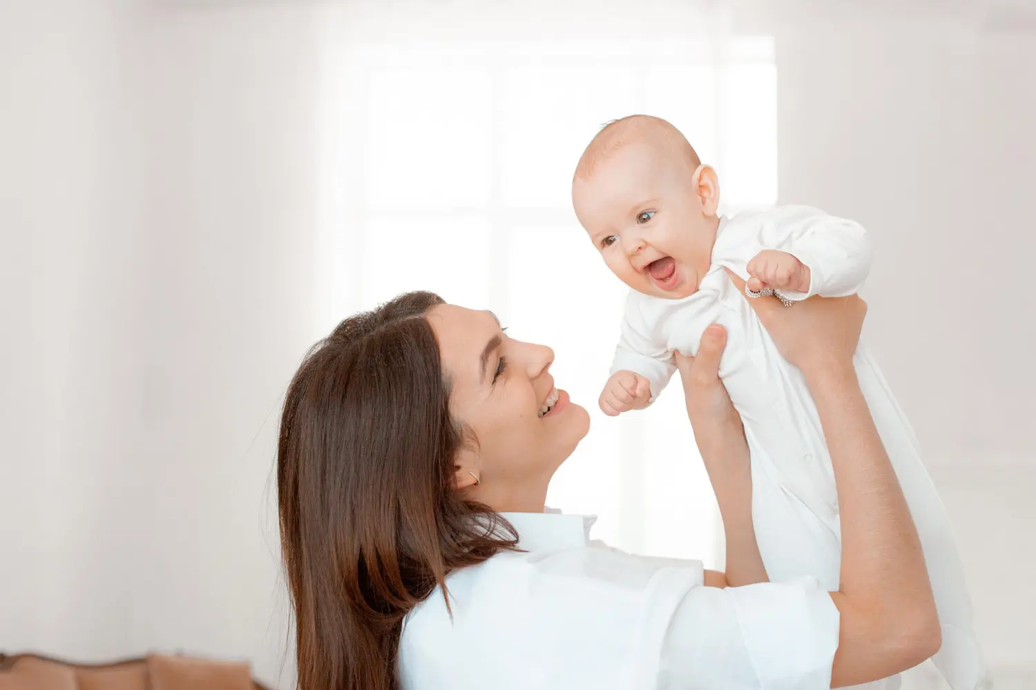 At Pediatric Dentistry and Orthodontics of Forsyth - Cumming in Cumming, GA. A woman in a white clothes holds a baby, emphasizing the importance of baby dentist visits for Apple Health ABCD Program—offering $0 dental care for ages 0–6.