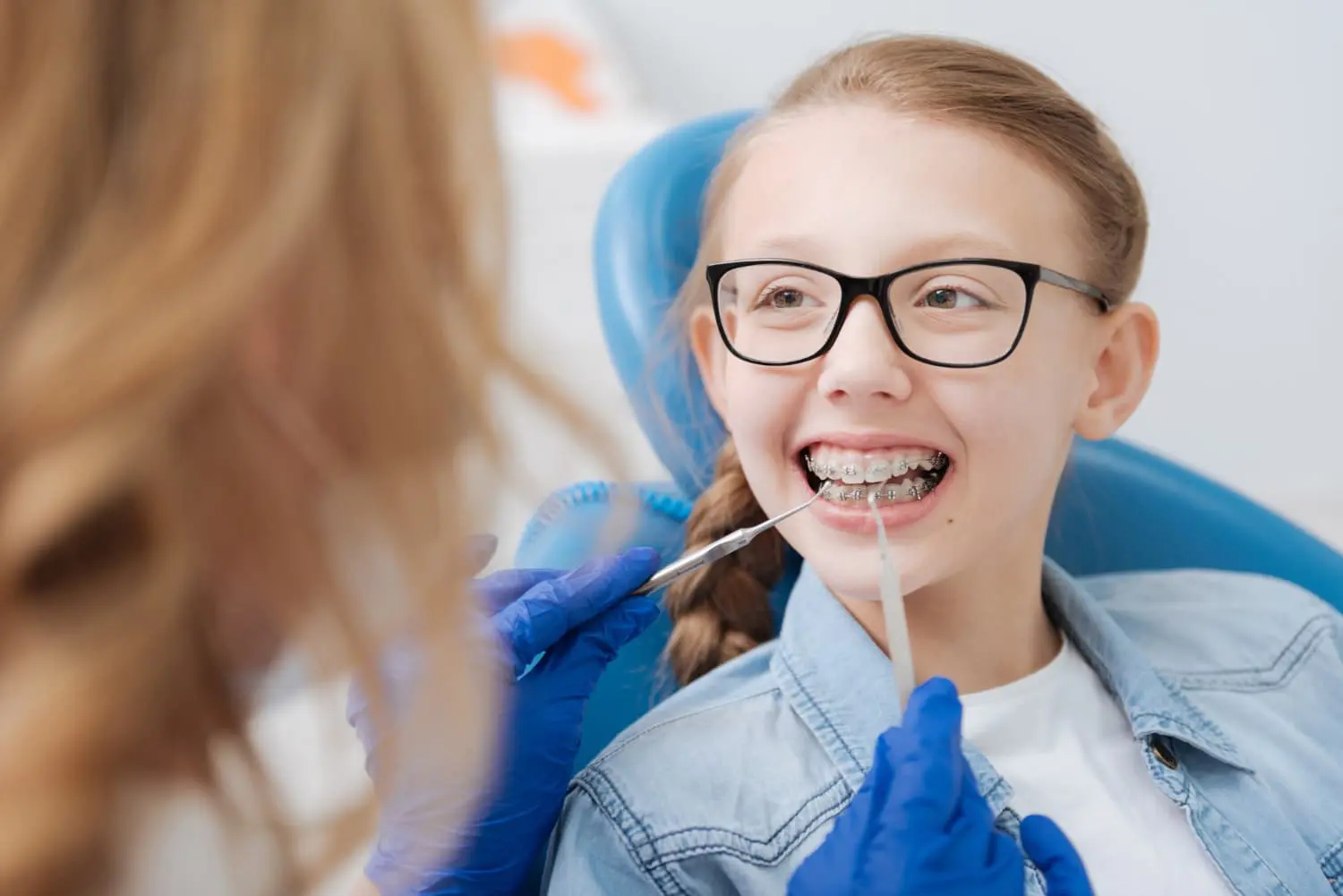 At Pediatric Dentistry and Orthodontics of Forsyth - Cumming in Cumming GA, a dentist gently examines a young girl’s teeth, providing comforting restorative dental care for anxious children.