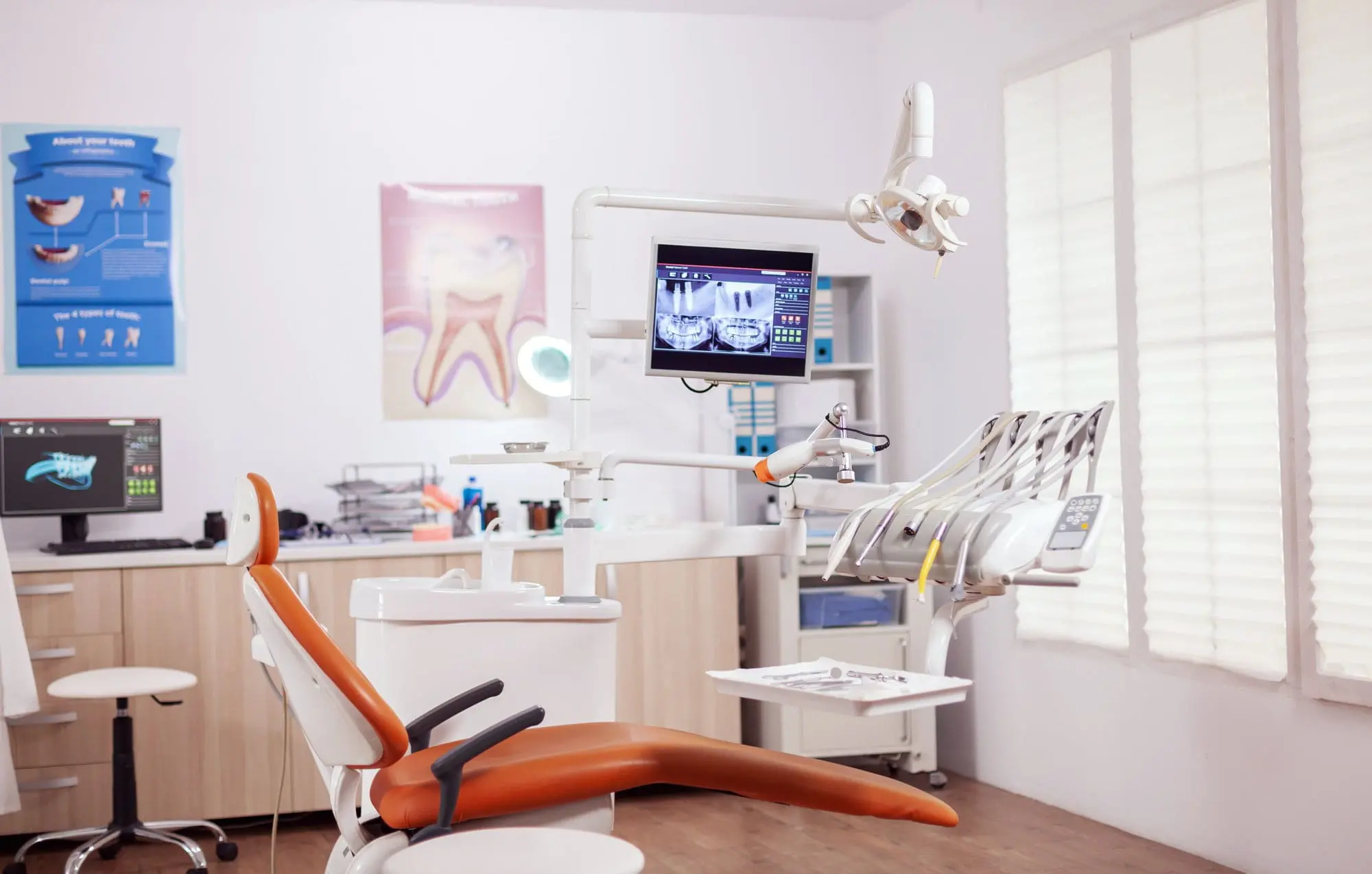 At Forsyth Pediatric Dentistry and Orthodontics in Cumming, GA, a modern dental office features an orange chair and X-ray monitor for overbite treatment.