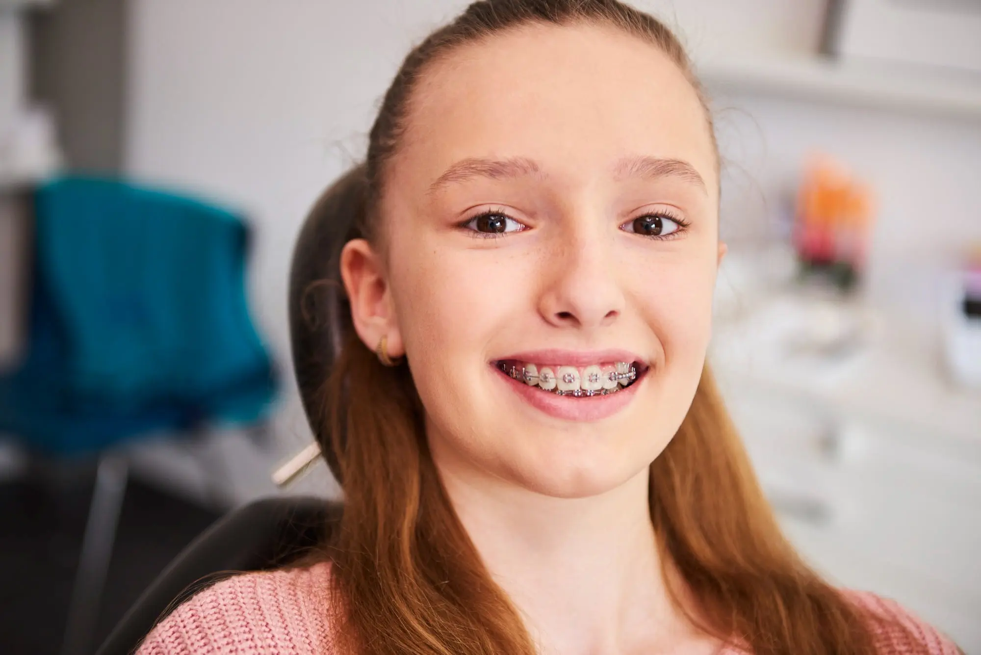 Smiling teenage girl with braces in a dental chair at Pediatric Dentistry and Orthodontics of Forsyth - Cumming in Cumming, GA.