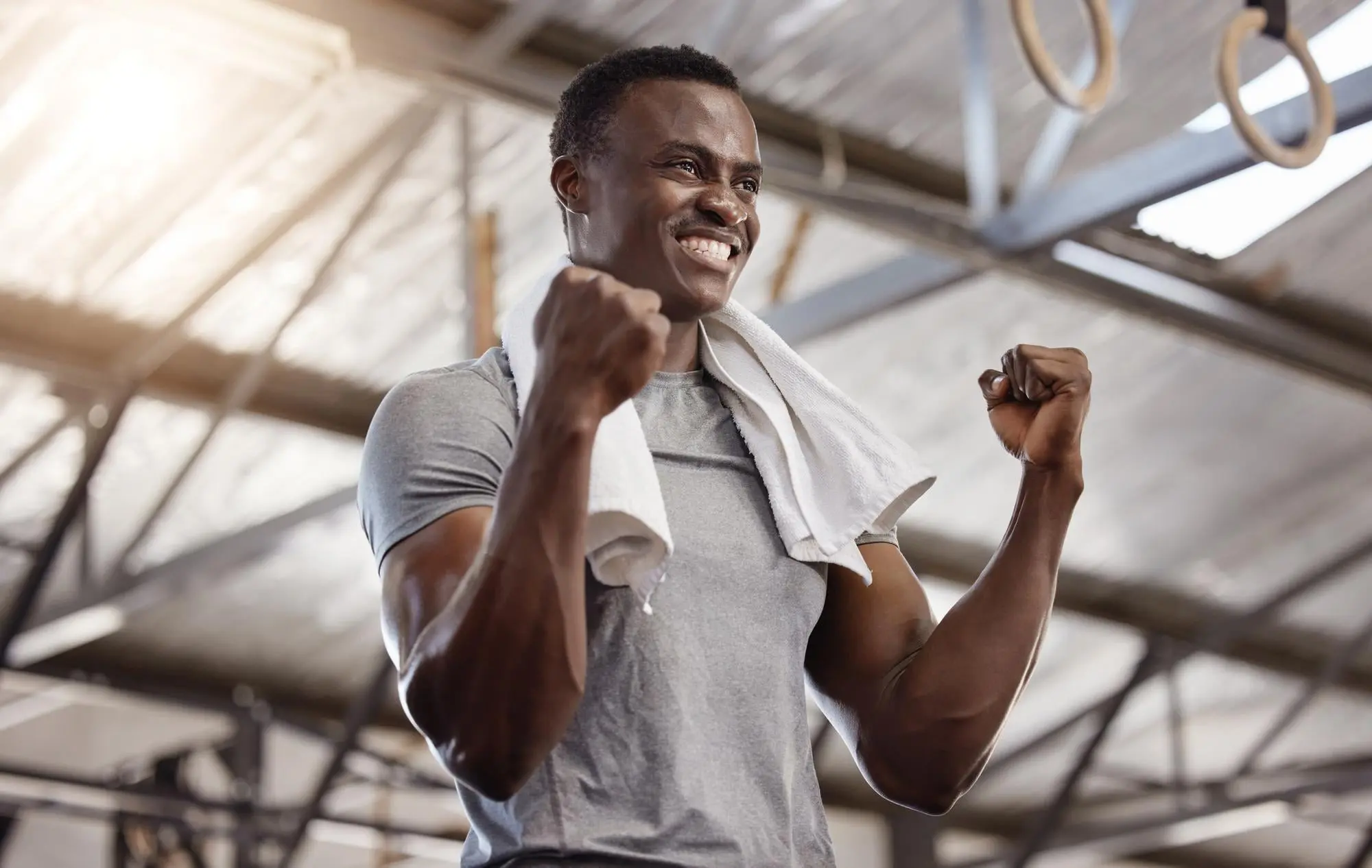 Smiling man with towel and raised fists indoors show prevention and management from mouth breathing in Cumming, GA.