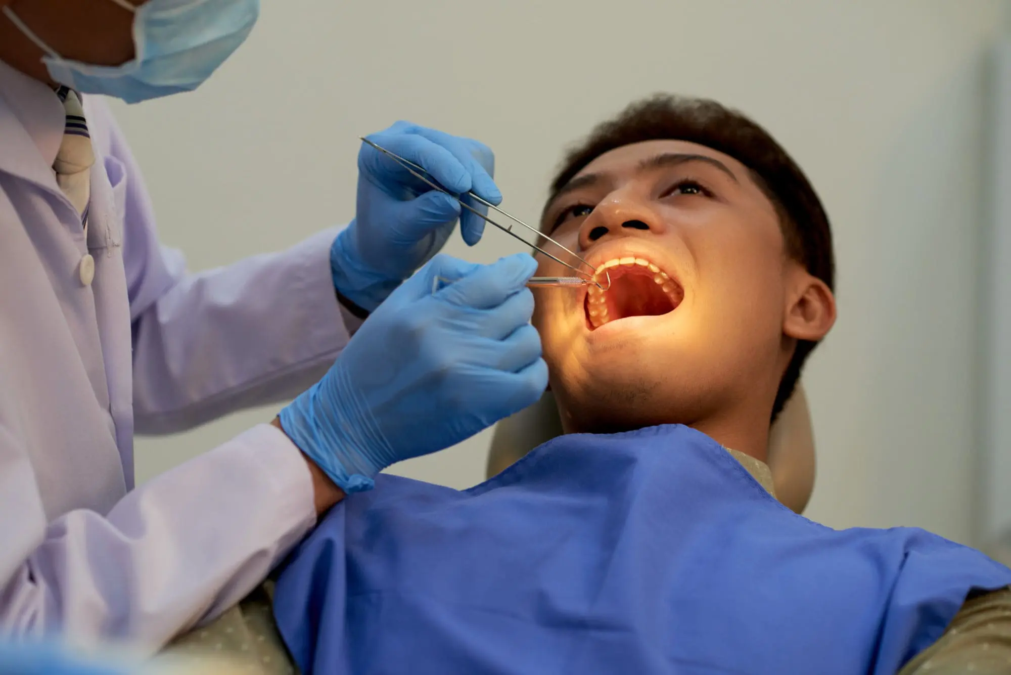 A gloved dentist examines a patient's mouth at Forsyth Pediatric Dentistry and Orthodontics in Cumming, GA for jaw surgery needs.