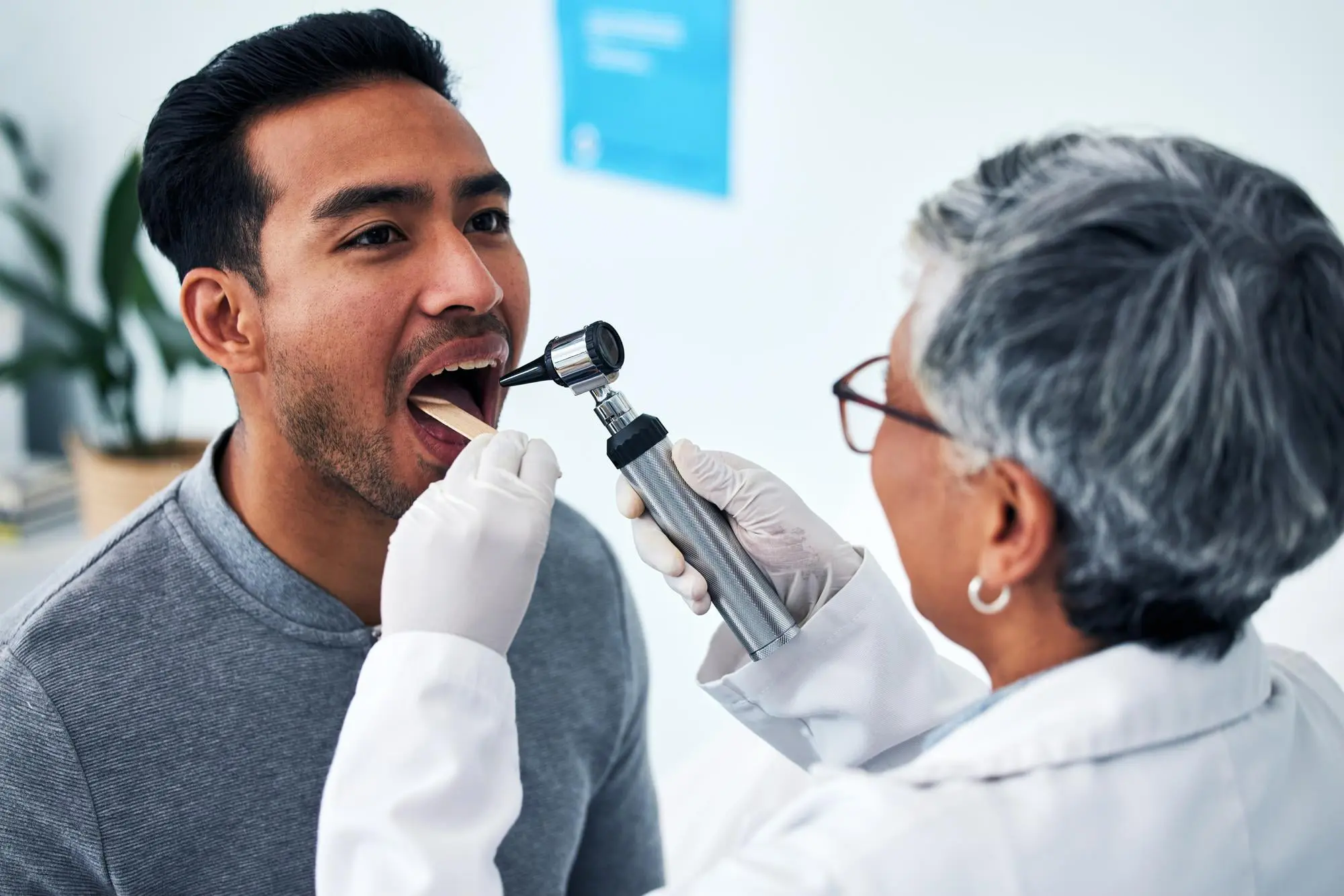 At Forsyth Pediatric Dentistry and Orthodontics in Cumming, GA, a professional checks a patient’s throat for tongue thrust issues.
