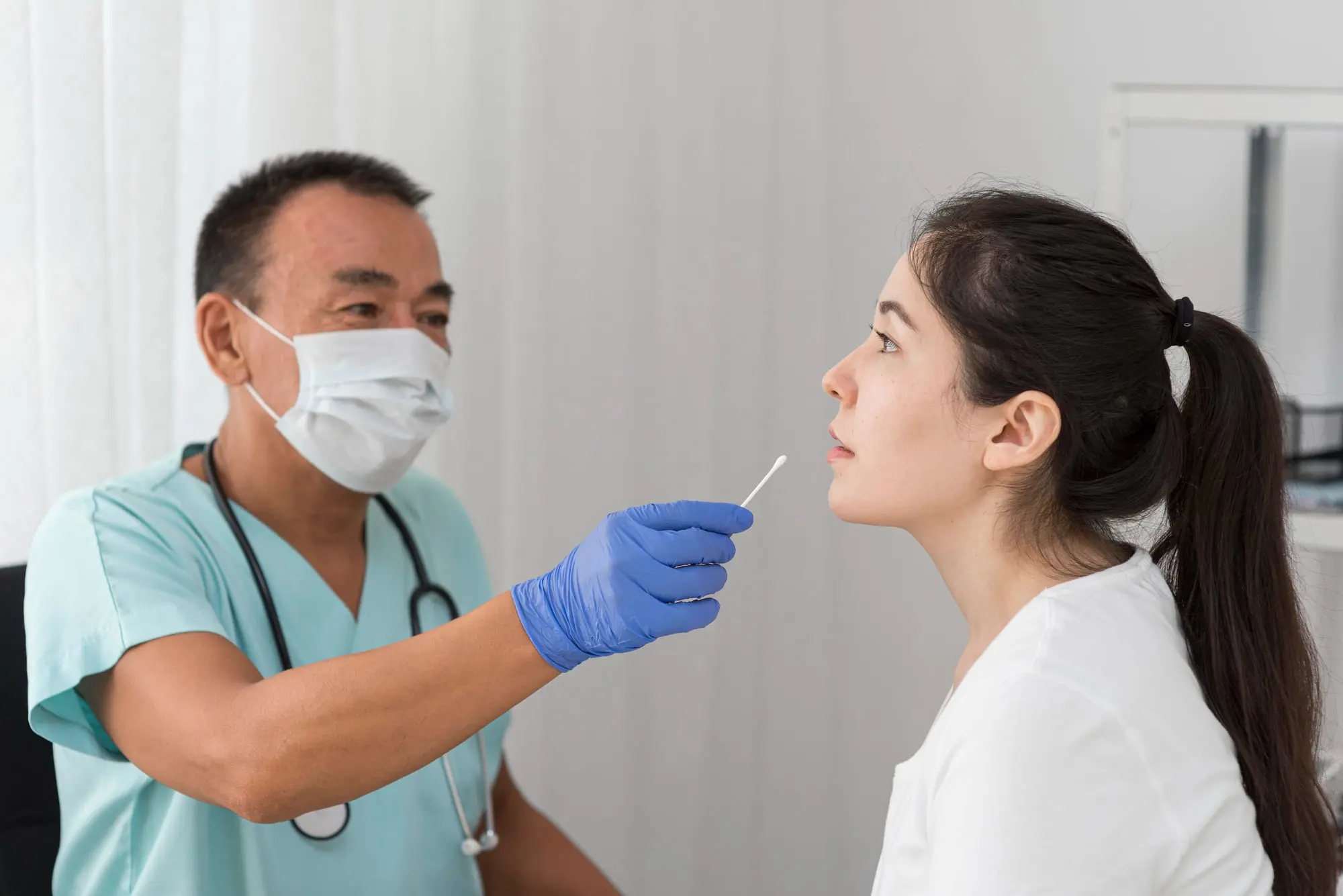 At Forsyth Pediatric Dentistry and Orthodontics in Cumming, GA, a masked clinician prepares to swab a woman's nose for jaw surgery testing.