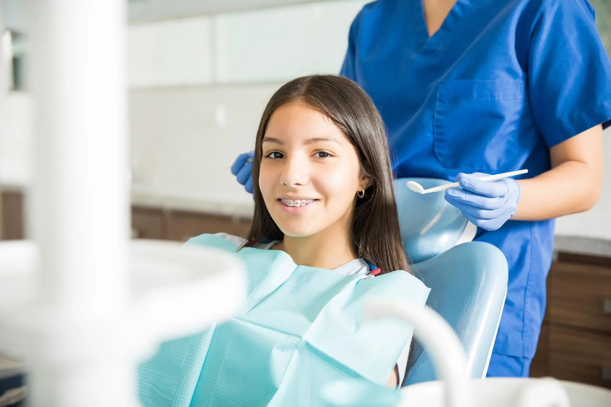 At Pediatric Dentistry and Orthodontics in Cumming, GA, a girl with braces consults a dental professional about airway ortho.