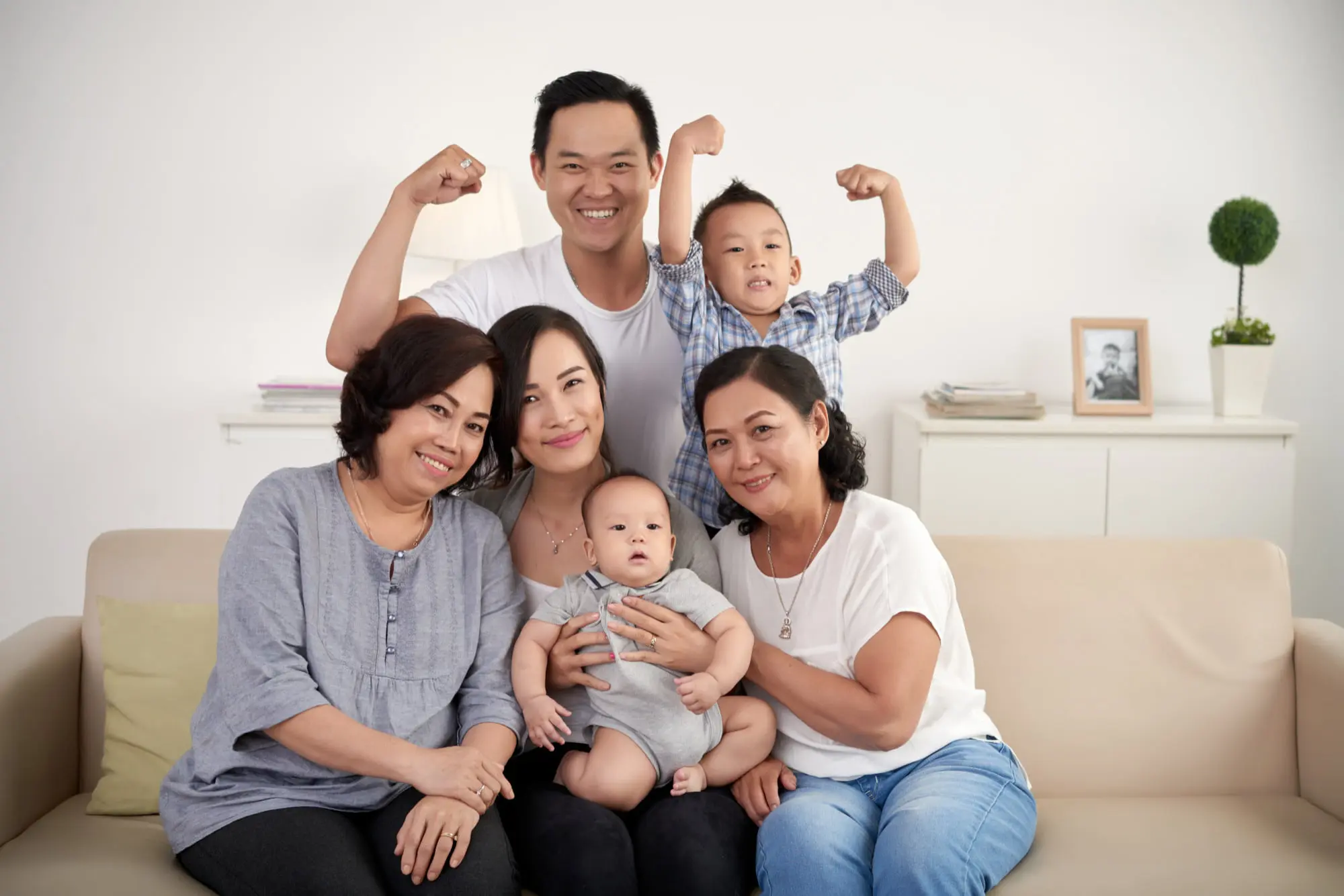 A smiling family of six poses on a sofa at Forsyth Pediatric Dentistry and Orthodontics in Cumming, GA; one child shows tongue thrust.